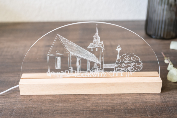 LED-Lampe mit gravierter Kirche von Malkwitz auf transparenter Acrylplatte mit warmweißem Licht und Holzsockel.